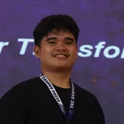 Denver Ugay smiling, wearing a Campus Press lanyard